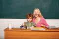 Portrait of schoolkids and teacher at lesson. Teacher helping young school boy with lesson.