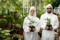 Portrait of scientists in clean suit holding potted plants Royalty Free Stock Photo