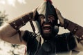 Portrait of screaming in rage ancient Spartan warrior in helmet
