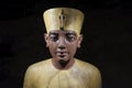 Portrait sculpture of pharaoh Tutenkhamun with black background. Close up view.