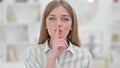 Portrait of Secretive Young Woman Putting Finger on Lips, Quiet Sign