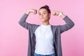 Portrait of self-confident teenage girl raising hands showing power, feeling independent. isolated on pink background