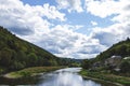A portrait of the semois river with on one side a small village and on the other a forest and a mountain Royalty Free Stock Photo