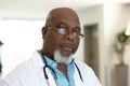 Portrait of senior african american male doctor in hospital corridor, with copy space Royalty Free Stock Photo