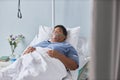Senior African American woman laying on bed in hospital room with oxygen support Royalty Free Stock Photo