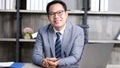 Portrait of senior asian businessman smiling and looking at camera while sitting at office Executive CEO asia man in formal Royalty Free Stock Photo