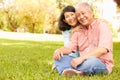 Portrait Of Senior Asian Couple Sitting In Park Together Royalty Free Stock Photo