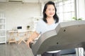 Portrait of senior asian lady walking on treadmill in home workout area, concept of senior people with health conscious