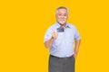 Senior asian man holding credit card and showing on hand isolated on yellow background Royalty Free Stock Photo