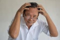 Portrait of senior asian man looking at camera scratching his head. Royalty Free Stock Photo