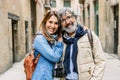 Portrait of senior attractive couple smiling at camera at city street