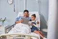 Senior black woman with little girl using digital tablet in hospital room Royalty Free Stock Photo