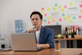 Portrait of Senior business Asian man working with laptop thinking business plan and holding pen Royalty Free Stock Photo
