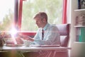 Portrait of a senior business man working in his office, he is typing a report on his laptop Royalty Free Stock Photo