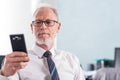 Portrait of senior businessman looking at his mobile phone Royalty Free Stock Photo