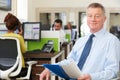 Portrait Of Senior Businessman Sitting In Busy Modern Office Royalty Free Stock Photo