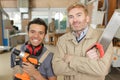 portrait senior carpenter with junior apprentice holding tools Royalty Free Stock Photo