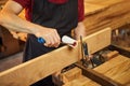 Portrait of a senior carpenter in uniform gluing wooden bars with hand pressures at the carpentry manufacturing Royalty Free Stock Photo