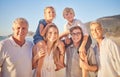 Portrait of a senior caucasian couple at the beach with their children and grandchild. Happy family relaxing on the Royalty Free Stock Photo