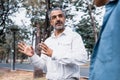 Portrait of a senior caucasian man giving advice and suggestion to his son while walking and discussion problem in the park, Royalty Free Stock Photo