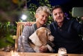 Senior couple with dog in the evening on terrace, taking selfie. Royalty Free Stock Photo