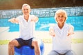 Portrait of senior couple doing aerobics at poolside Royalty Free Stock Photo