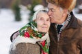 Portrait of senior couple. Elderly man kiss his wife in weighty. old couple walking in the park in winter time. Happy