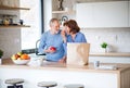 A portrait of senior couple indoors at home, unpacking shopping. Royalty Free Stock Photo