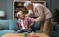 Portrait of senior couple in living room, Mature woman with pain in the shoulder. Upper arm pain, woman neck and shoulder pain and Royalty Free Stock Photo