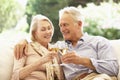 Portrait Of Senior Couple Relaxing On Sofa With Glass Of Wine Royalty Free Stock Photo