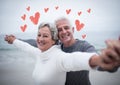 Portrait of senior couple standing with arms outstretched