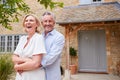 Portrait Of Senior Couple Standing Outside Front Door Of Home Royalty Free Stock Photo