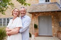 Portrait Of Senior Couple Standing Outside Front Door Of Home Royalty Free Stock Photo
