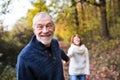 A portrait of a senior couple walking in an autumn nature. Royalty Free Stock Photo