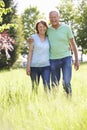 Portrait Of Senior Couple Walking In Summer Countryside Royalty Free Stock Photo
