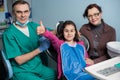 Portrait of senior dentist and young girl with her mother on the dental visit at the dental office Royalty Free Stock Photo