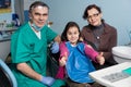 Portrait of senior dentist and young girl with her mother on the first dental visit at the dental office Royalty Free Stock Photo