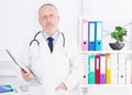 Portrait of senior doctor in medical office.Man in white uniform. Medical insurance. Copy space. Quality medicine concept. Copy sp Royalty Free Stock Photo