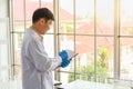 Portrait of senior doctor scientist wearing safty glasses and blue rubber gloves tak a note on clipboard in working laboratory