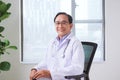 Portrait of senior doctor sitting at his desk in medical office Royalty Free Stock Photo