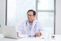 Portrait of senior doctor sitting at his desk in medical office Royalty Free Stock Photo