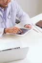 Portrait of senior doctor sitting at his desk in medical office Royalty Free Stock Photo