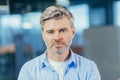 Portrait of senior experienced businessman, man thoughtfully looking at camera close up photo