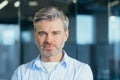 Portrait of senior experienced businessman, man thoughtfully looking at camera close up photo