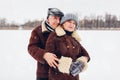 Portrait of senior family couple walking outdoors during snowy winter weather. Mature people hugging Royalty Free Stock Photo