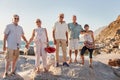 Portrait Of Senior Friends Standing On Rocks By Sea On Summer Group Vacation Royalty Free Stock Photo