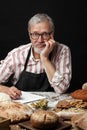 Elderly man demonstrating assortment of bakery. Homemade pastries, rural style Royalty Free Stock Photo