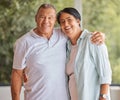 Portrait of a senior happy couple smiling, standing at home in front of a window looking at the camera. Mature hispanic Royalty Free Stock Photo