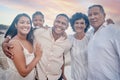 Portrait of a senior hispanic couple at the beach with their children and grandchild. Mixed race family relaxing on the Royalty Free Stock Photo