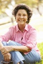 Portrait Of Senior Hispanic Woman Sitting In Park Royalty Free Stock Photo